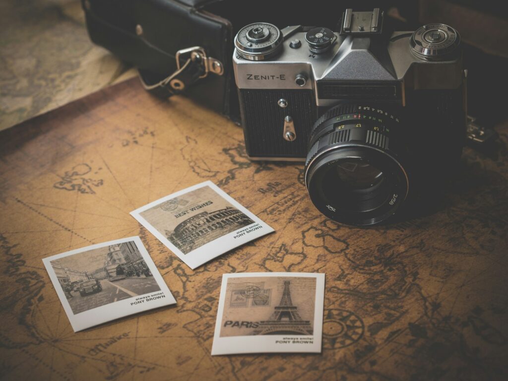 Camera and printed travel photos on a map